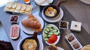 A breakfast table with various dishes including eggs, croissants, and bread. - Le Six Resort Hotel (Batroun)