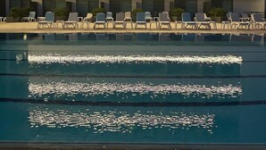 A modern hotel with a pool, lounge chairs, and a multi-story building with balconies. - Le Six Resort Hotel (Batroun)