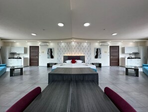 Un dormitorio amplio con una cama grande, dos mesitas de noche, un armario y un vestidor empotrado.
