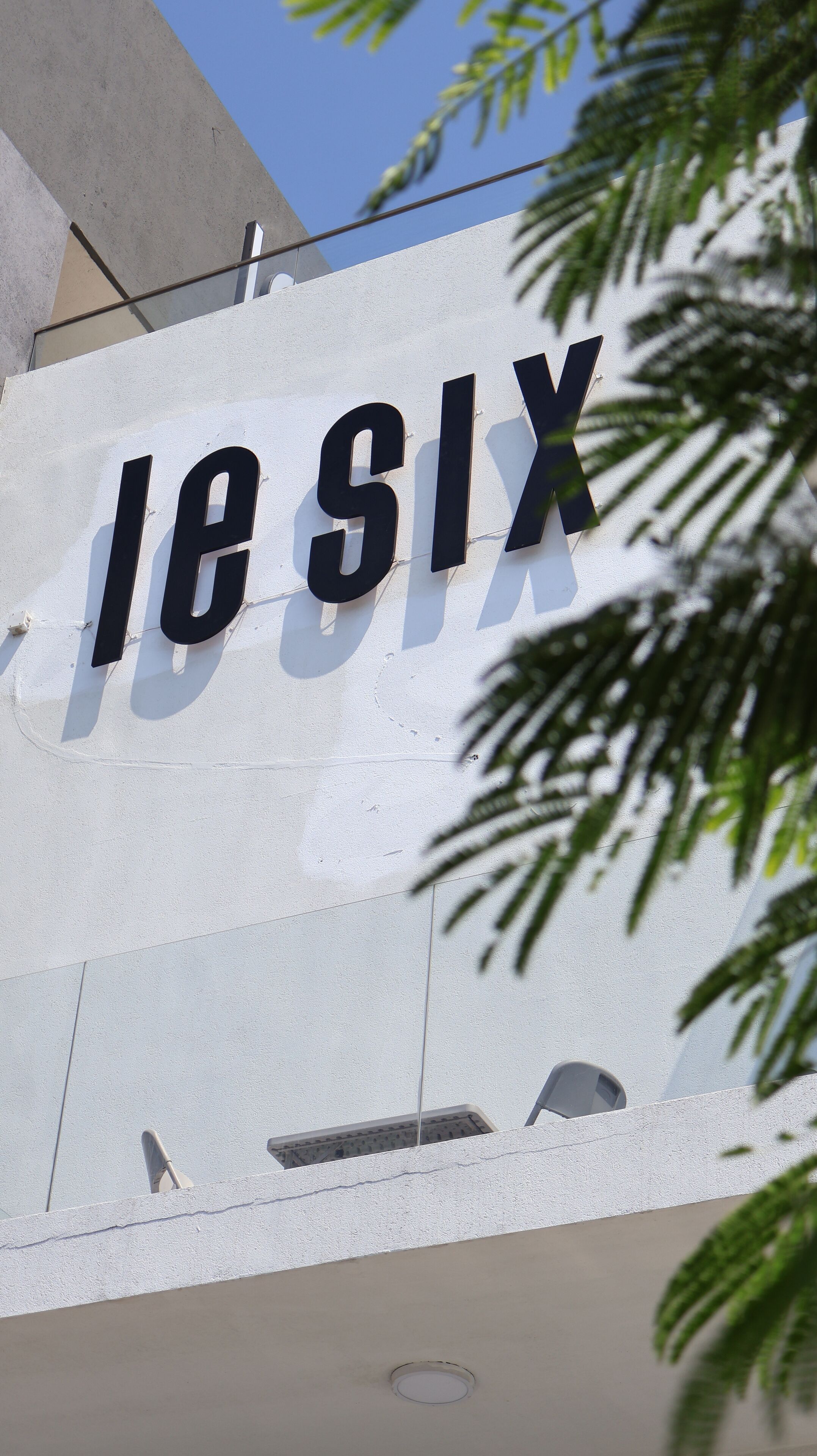 A sign with the text "les SIX" on a white wall.