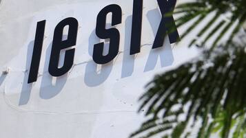 A sign with the text "les SIX" on a white wall.