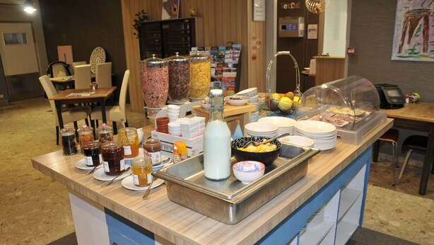 A buffet setup with various food items and condiments. - Hotel Nestor (Bourg-les-Valence)