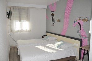 Un dormitorio con cama, mesita de noche, lámpara y pared con diseño en rosa y negro.