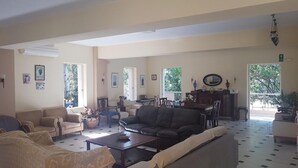 Un salon spacieux comprenant un canapé, une table basse et un coin repas avec des chaises et une table.