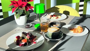 A table with a potted plant, a glass of tea, a cup of coffee, and plates of food.
