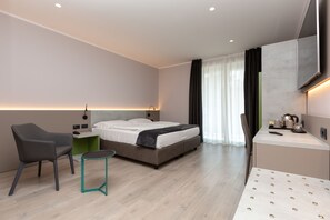 Una habitación de hotel moderna con una cama, un escritorio, una silla y una mesita.