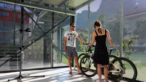 A room with a large window, a metal chair, and a bicycle.
