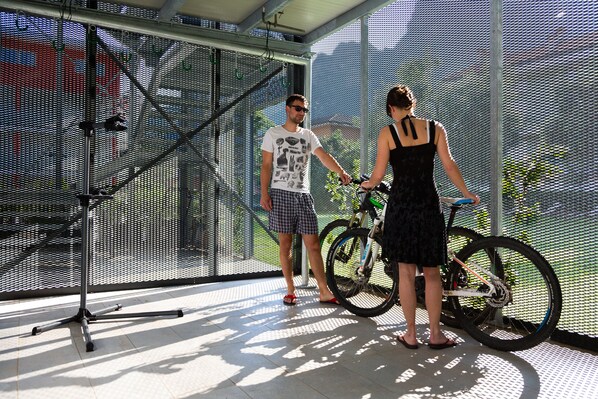 Una habitación con un ventanal grande, una silla de metal y una bicicleta.