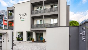 A modern building with a sign reading "GARDA LIFE". It features a two-story structure with balconies and a paved entrance area.