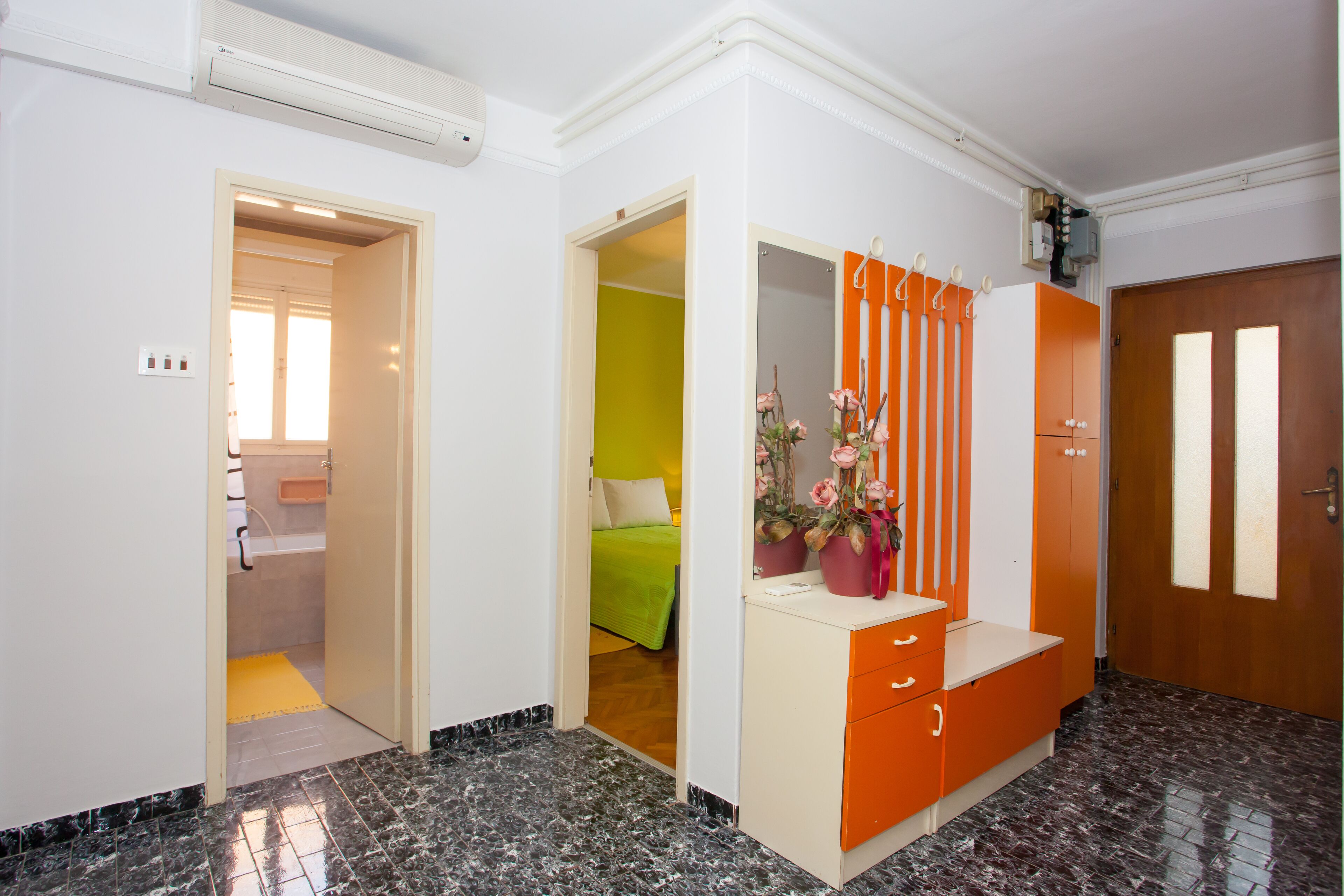 Quarto de hotel com banheiro, cama, penteadeira com espelho e guarda-roupa.