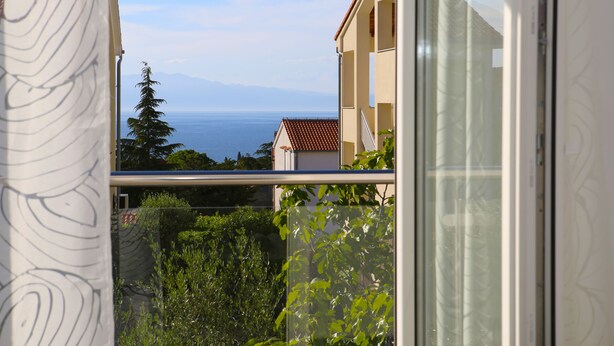 Ein Balkon mit Blick auf das Meer und die Berge.