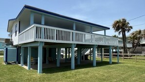 Ein zweistöckiges Haus mit verdeckter Veranda und einer kleinen Terrasse.
