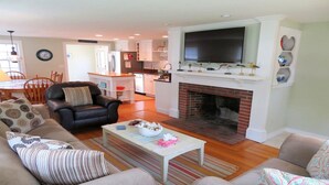 Ein Wohnzimmer mit Kamin, einer Couch, einem Couchtisch und einem Fernseher.