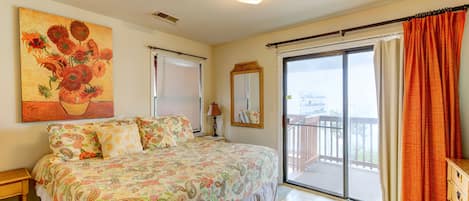 A bedroom with a bed, a large window, and a balcony.