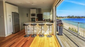 Une cuisine moderne avec un coin bar et vue sur l’océan.