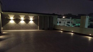 An outdoor terrace with a stone wall and lighting fixtures. - Hotel Kailash (Birgunj)