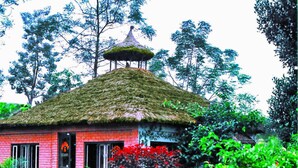 A house with a thatched roof and a small tower-like structure on top. - Rainbow Safari Resort (Sauraha)