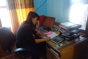 A person working at a desk with a laptop, calculator, and papers.