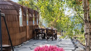 A rustic wooden building with a thatched roof, a stone pathway, and a table with chairs. - Villa Heidi (Stange)