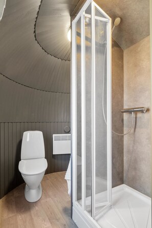 A modern bathroom with a shower enclosure, a toilet, and a towel rack. - Villa Heidi (Stange)