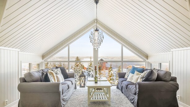 A spacious attic room with high ceilings, large windows, and a chandelier. - Villa Heidi (Stange)