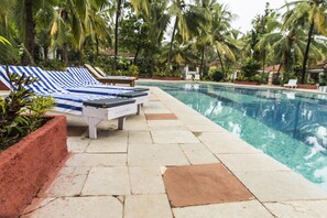 A poolside area with lounge chairs and a pool. - Shikara Beach Resort (Cavelossim)