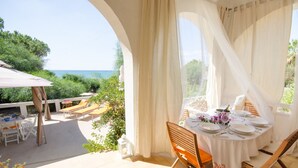 Una terraza con una mesa dispuesta para comer, con vistas panorámicas al mar.