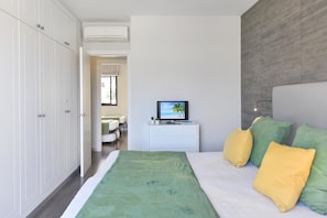 A bedroom with a bed, a TV, and a wardrobe. - Meloneras Bahia 7 by VillaGranCanaria (Maspalomas)