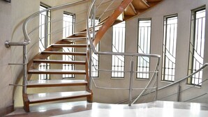 A spiral staircase with metal railings and wooden steps, leading to an upper floor. - Lahore Home Stay (Lahore)