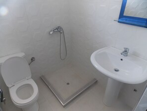 A bathroom with a toilet, a shower, and a sink. - Doka Luxury Apartments (Sarandë)