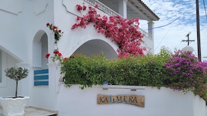 A white building with a sign reading "KA LMERA" and a small tree in a white pot. - Kalimera Studios and Apartments (Corfu)
