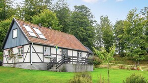 A traditional half-timbered house with a sloped roof, a flag, and a small staircase leading to the entrance. - Awesome home in östra sönnarslöv (Östra Sönnarslöv)