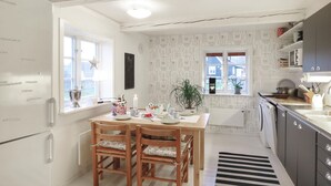 A compact kitchen with a dining table, chairs, a refrigerator, a sink, and a window with a view. - Awesome home in östra sönnarslöv (Östra Sönnarslöv)