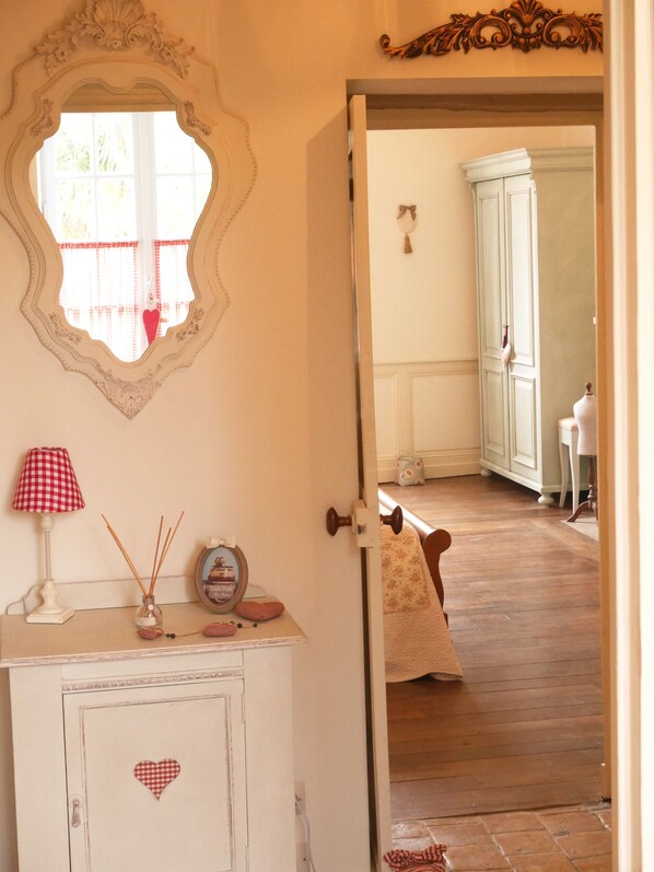 A room with a white cabinet, a mirror, a red and white checkered lamp, and a small clock. - L'Arbre d'Ange (Montmorillon)