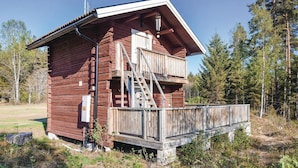 A wooden cabin with a balcony, a ladder, and a small porch. - Beautiful home in Ambjörby with sauna (Ambjörby)