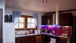 Una cocina con armarios de madera, un refrigerador, un microondas y un lavaplatos.