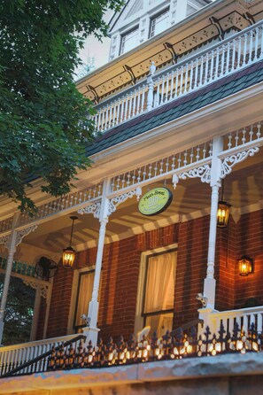 A building with a porch, a sign reading 'Main Street,' and a brick facade. - Main Street Inn (Parkville)