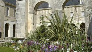 A courtyard with stone architecture, including arches and a fountain. - Cozy T2 Apartment with South-Facing Balcony and Private Parking Near Beach (Les Sables-d'Olonne)