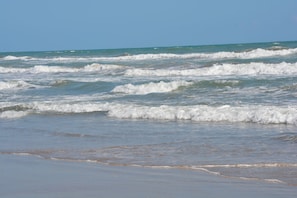 A beach with waves approaching the shore.