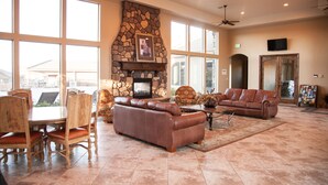 A spacious living room with a stone fireplace, leather sofas, and a dining area with wooden chairs. - SPOTLESS,Booking for SUMMER FALL AND WINTER 3bdrm 2bth ONE LEVEL Great location! (Washington)