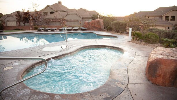 A swimming pool with a hot tub, lounge chairs, and a stone rock feature. - SPOTLESS,Booking for SUMMER FALL AND WINTER 3bdrm 2bth ONE LEVEL Great location! (Washington)