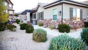 A residential area with houses featuring stone and brick exteriors, a gravel driveway, and various shrubs. - SPOTLESS,Booking for SUMMER FALL AND WINTER 3bdrm 2bth ONE LEVEL Great location! (Washington)