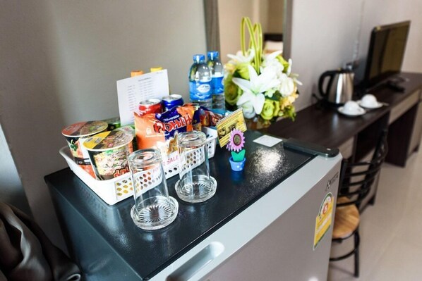 A hotel reception area with a counter displaying snacks, drinks, and a menu. - Thana Residence (lam luk ka)