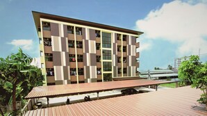 A multi-story building with a flat roof and a covered outdoor area with a red roof.