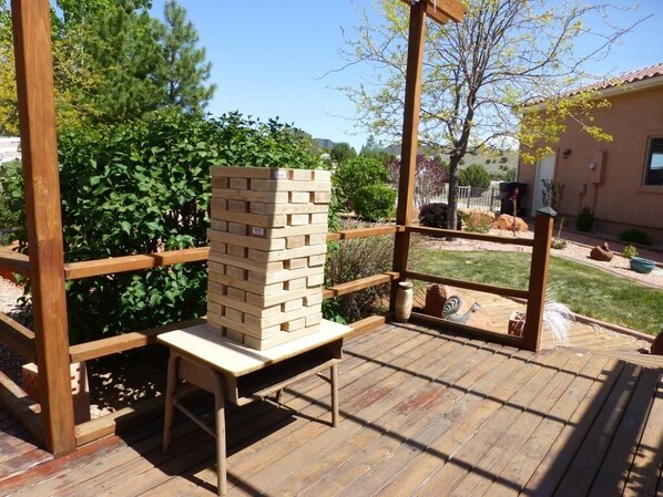A wooden deck with a brick structure, a wooden bench, and a metal gate.