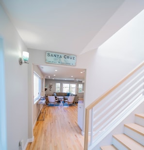 A modern interior with a staircase, wooden flooring, and a sign reading "SANTA CRUZ".