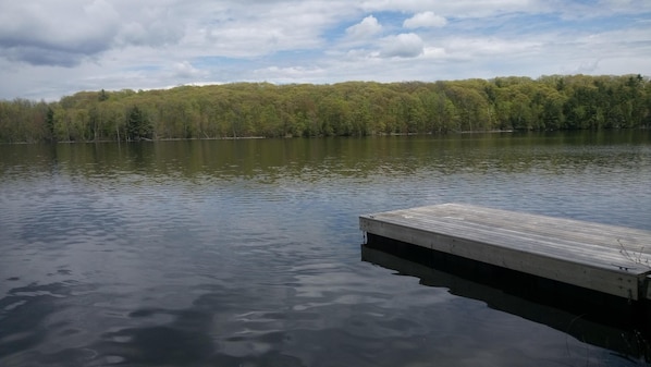 Ein ruhiger See mit einem hölzernen Steg, der ins Wasser ragt.