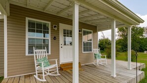 A wooden porch with white rocking chairs and a white door. - A Tennessee Tiny House: A Quiet Readaway Retreat for Rest & Reconnection (Clarksville)