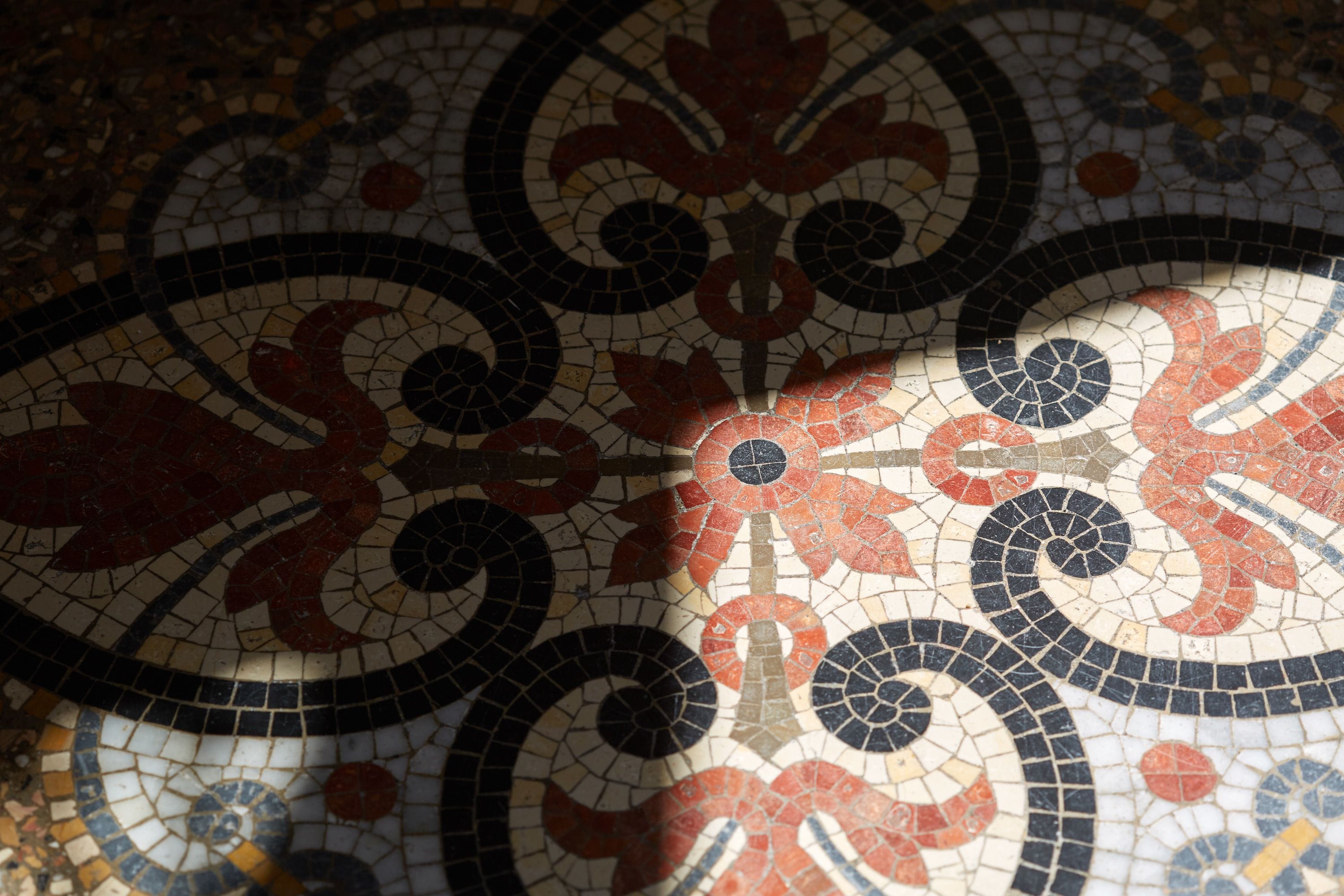 A close-up of a mosaic floor with intricate patterns and designs.