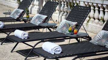 Een seizoensgebonden buitenzwembad, parasols voor strand/zwembad